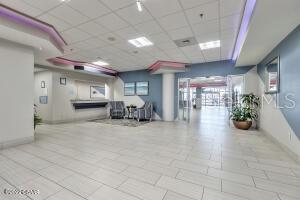 Condominium lobby with a reception counter, seating area, and purple ceiling accents.