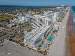 Aerial view of beachfront condominiums with a pool beside the Daytona Beach shoreline.