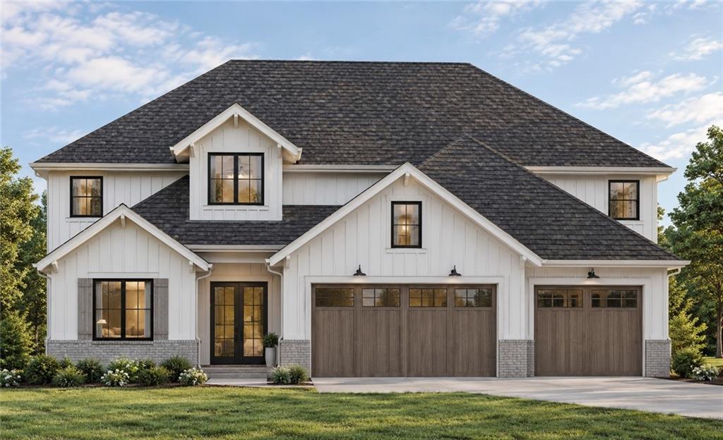 White two-story house with multiple gables, stone accents, and a three-car garage.