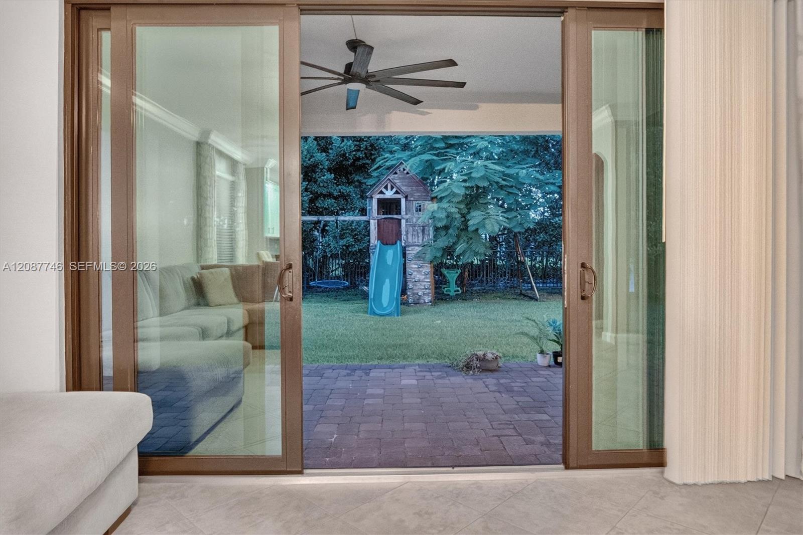 Living room opens through sliding glass doors to a patio and backyard playset.