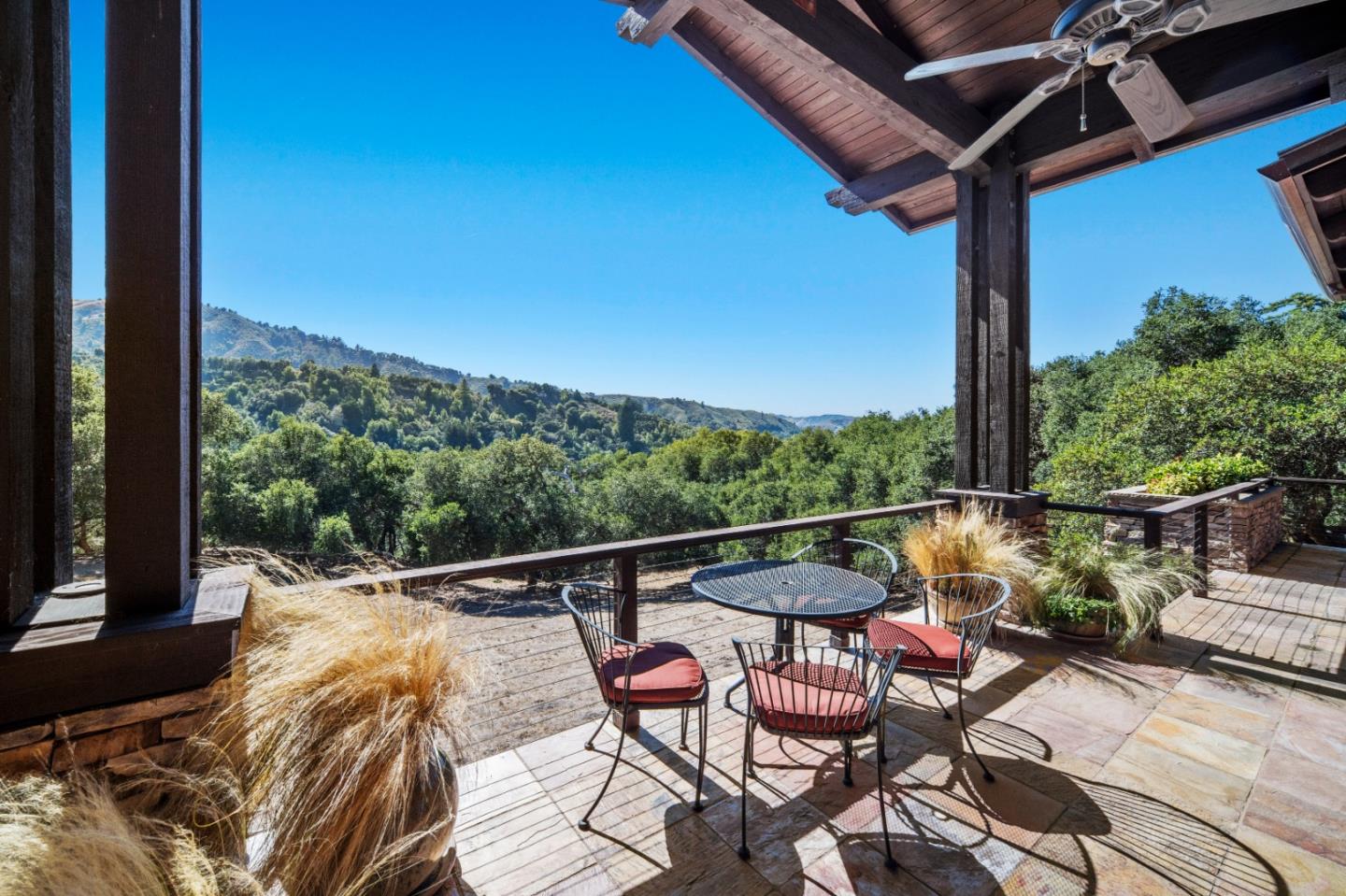 Covered patio with outdoor dining set overlooking wooded hills