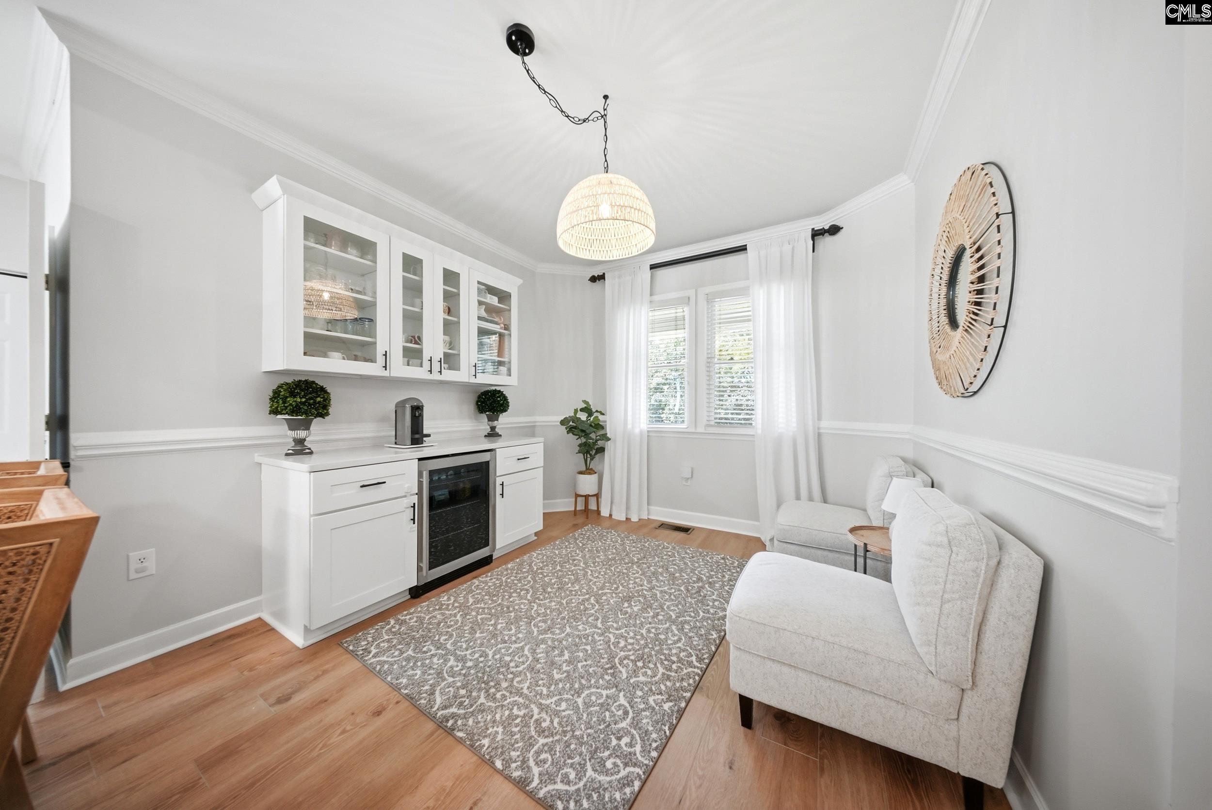 Sitting room with white sectional, patterned rug, glass-front cabinets, and beverage cooler