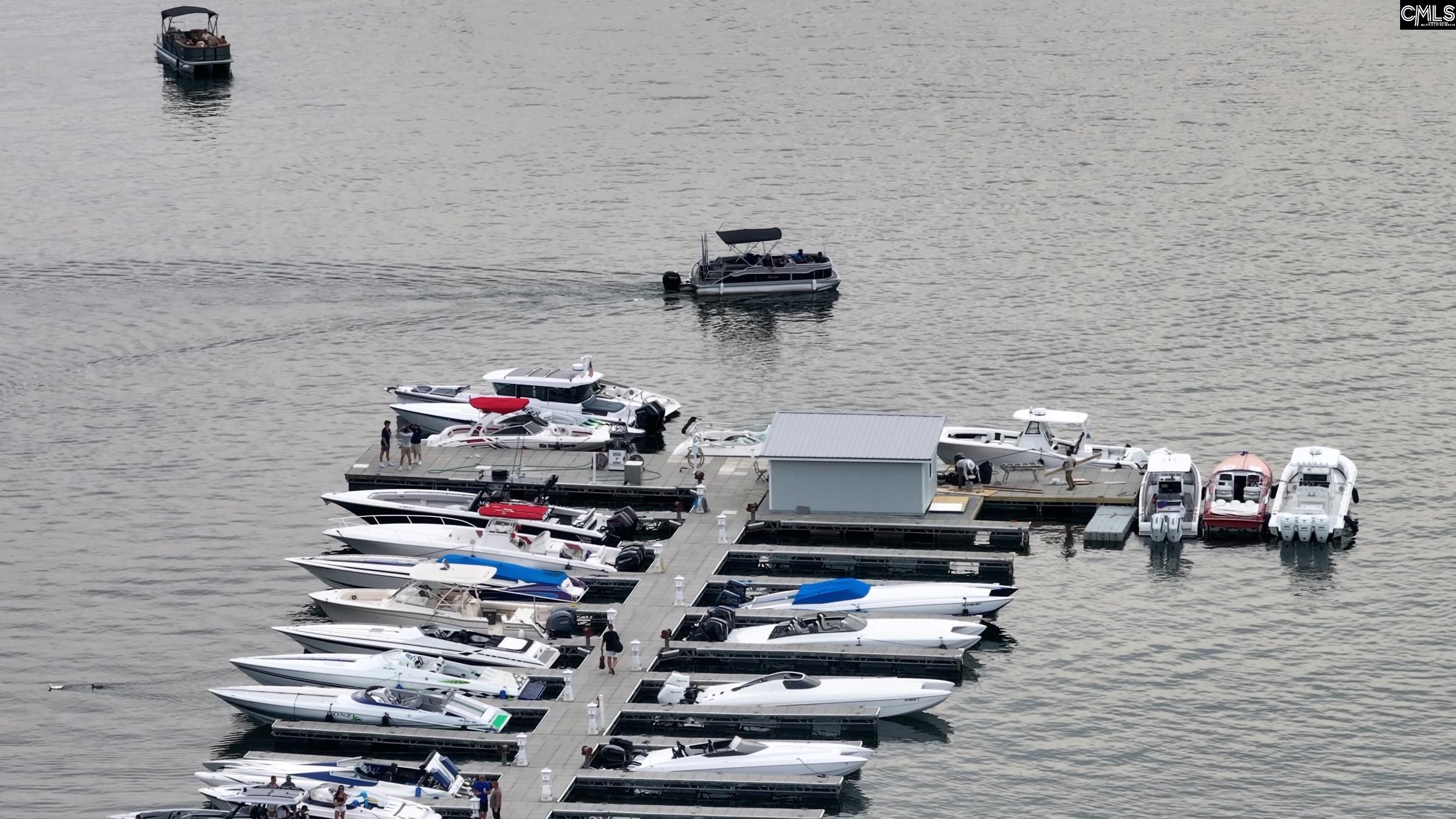 Marina with boats lining a network of docks on open water.