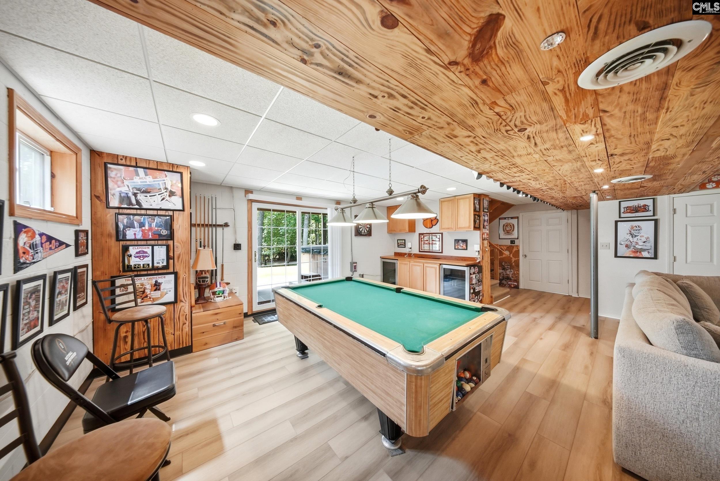 Recreation room with a pool table, sports memorabilia, wood ceiling, and built-in cabinetry.
