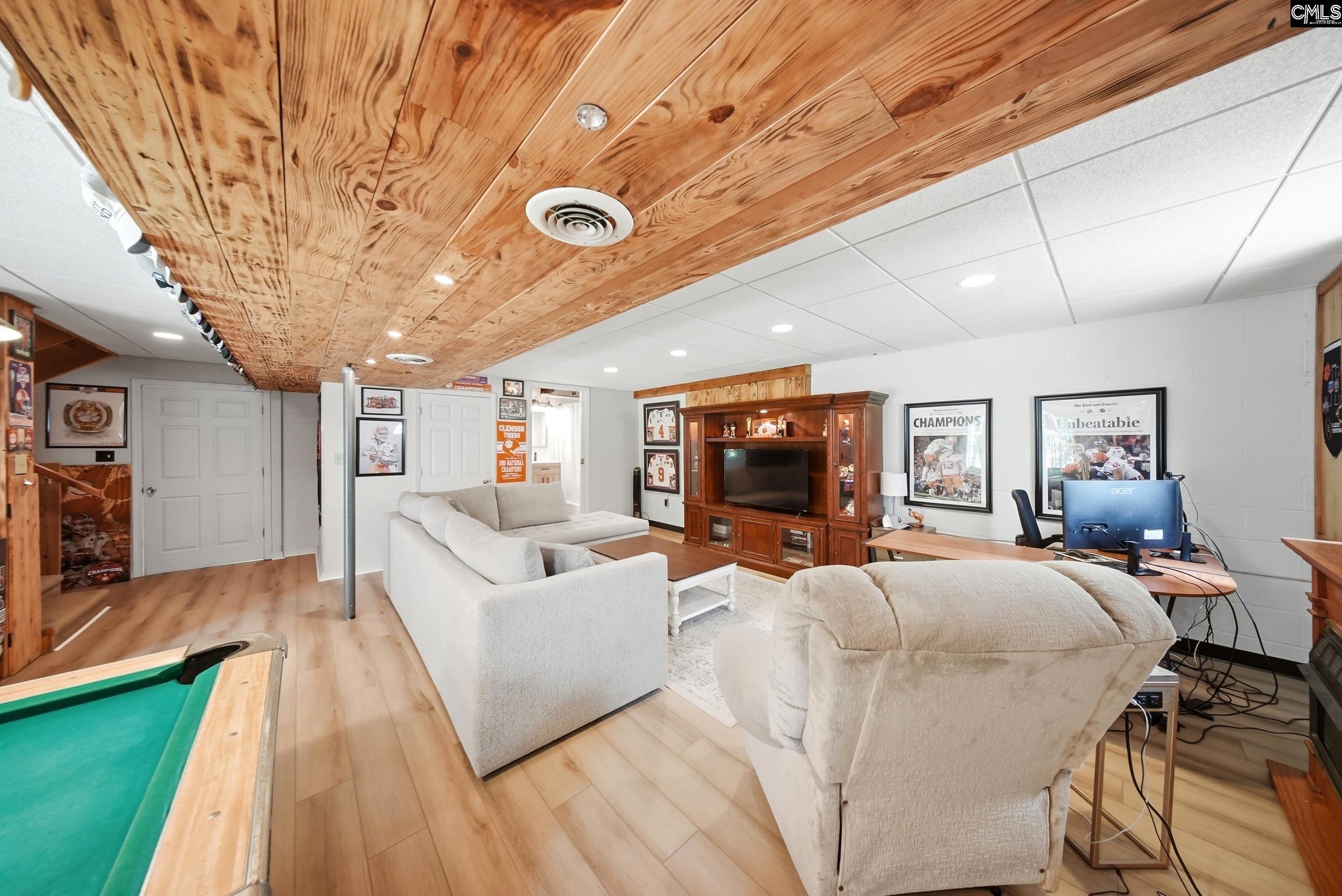 Furnished recreation room with a pool table, sports memorabilia, and a distinctive wood-plank ceiling.