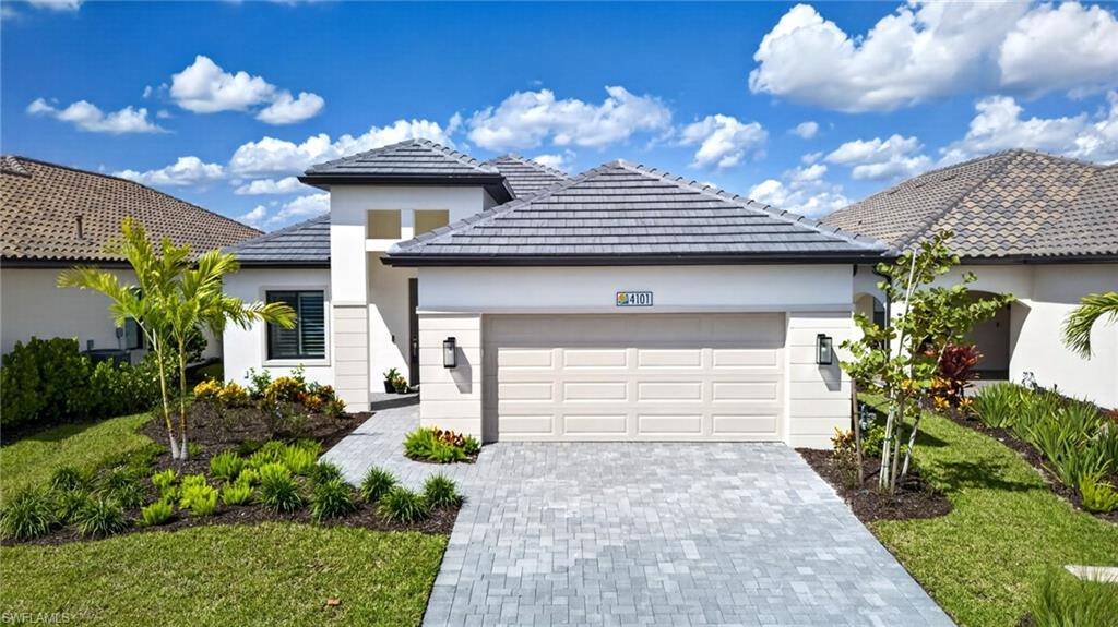 Modern white home with a gray tiled roof, double garage, and landscaped front yard.