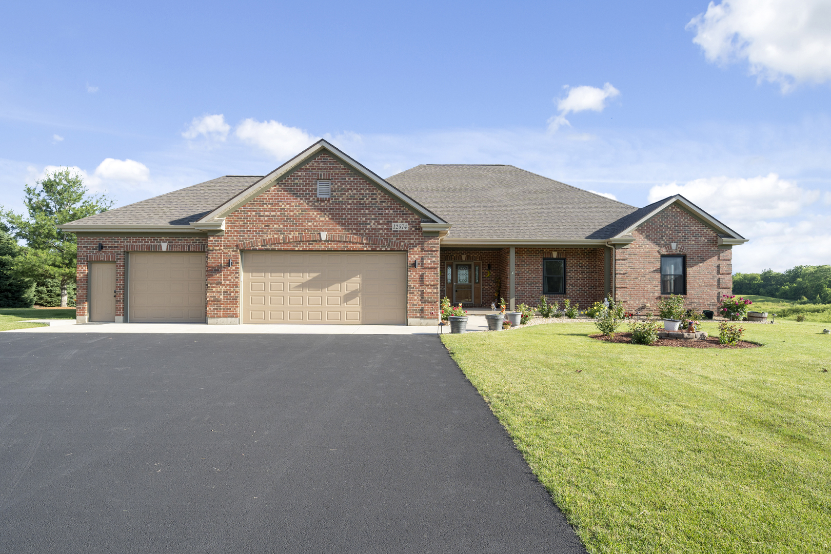 Brick home at 12574 Andrew Street with a three-car garage and landscaped lawn.