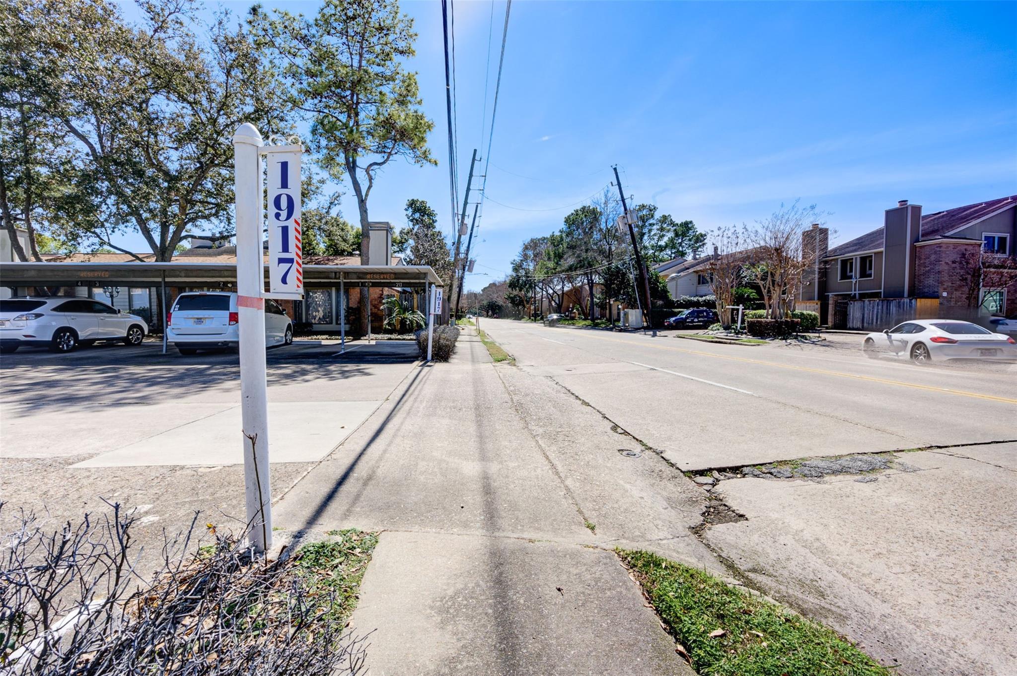 Augusta Drive property with a tall 1917 sign beside covered parking and a residential street.