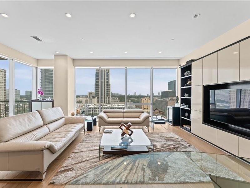 High-rise living room with cream sofas and floor-to-ceiling windows overlooking the city.