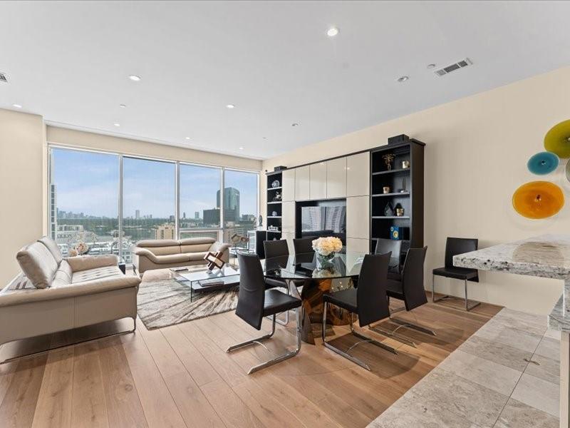 Open-plan living and dining room with floor-to-ceiling windows overlooking the Houston skyline.