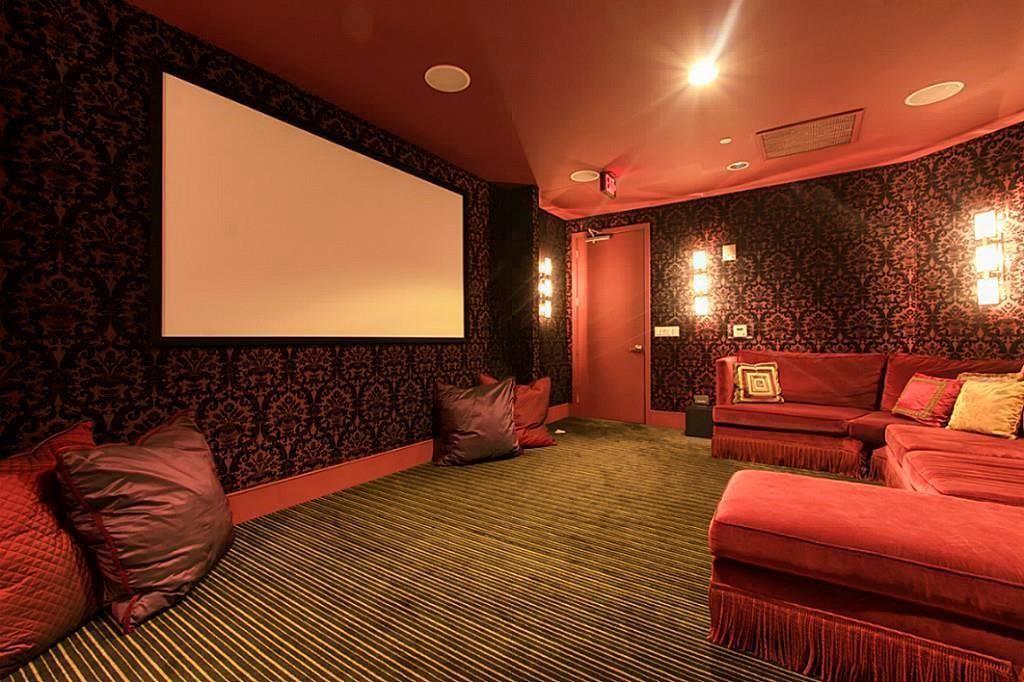 Home theater with a large screen and red sectional seating.