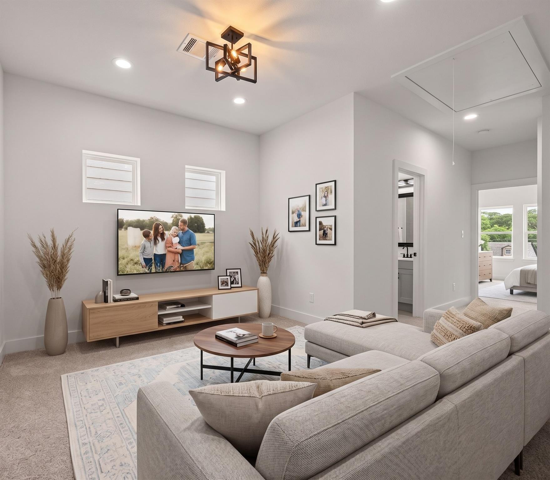 Staged living room with a gray sectional, round coffee table, and vaulted ceiling.