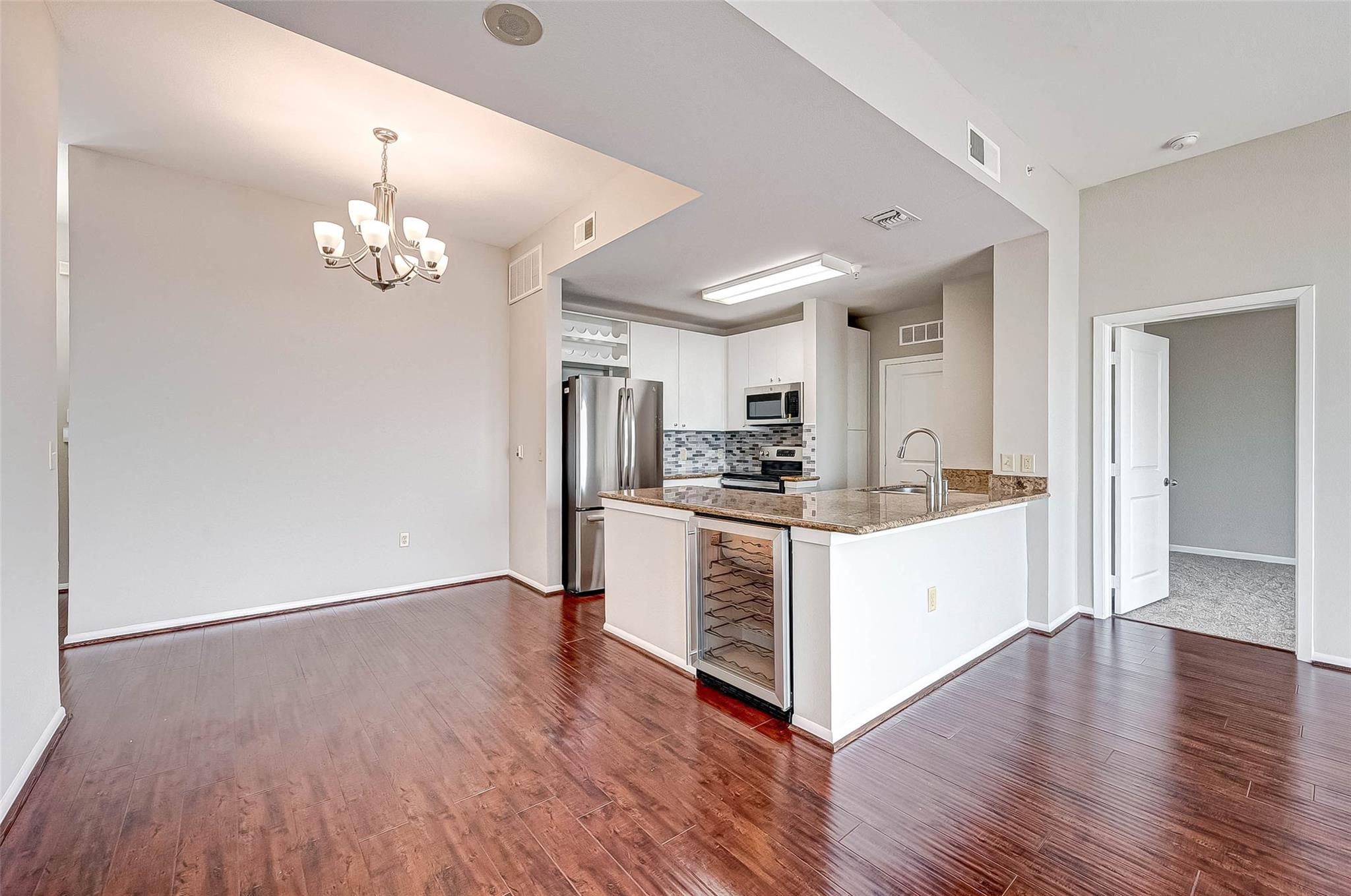 Open-plan kitchen and dining area with granite breakfast bar and stainless steel appliances