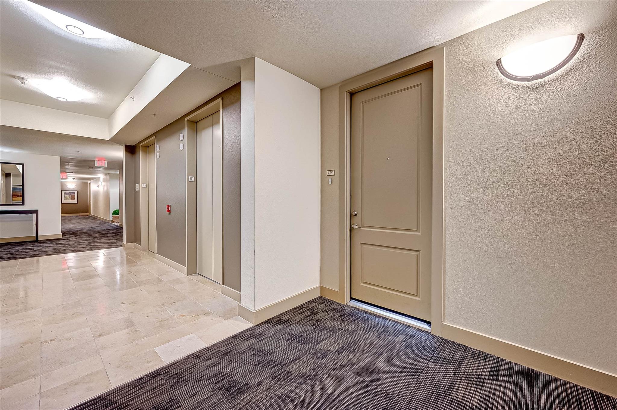 Condominium hallway with the 2106 door beside two elevators and a tiled corridor.
