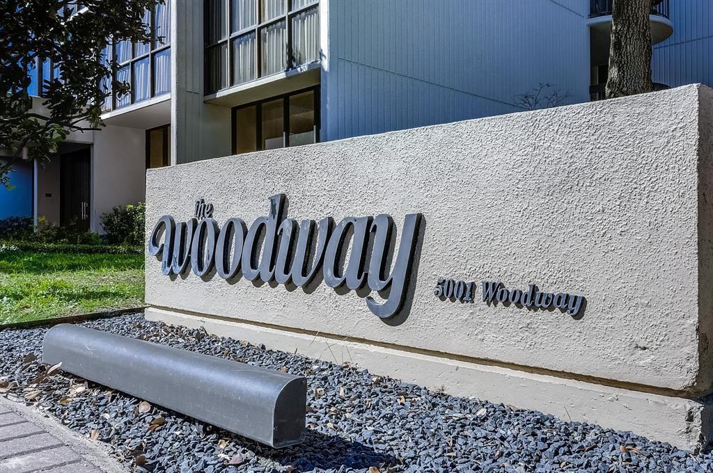 The Woodway condominium building behind its 5001 Woodway entrance sign.