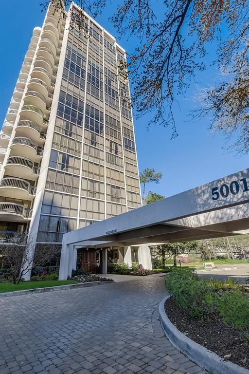 Residential tower with curved balconies and a driveway porte-cochère marked 5001.