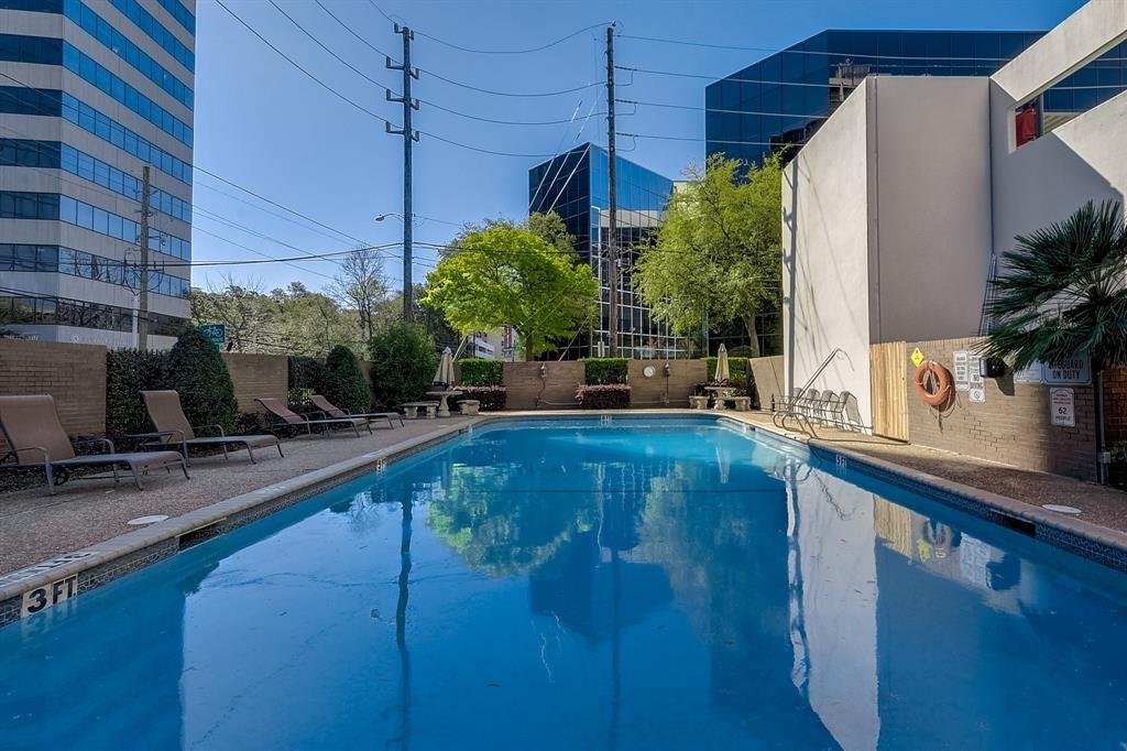 Outdoor swimming pool with lounge chairs and office buildings surrounding the courtyard.