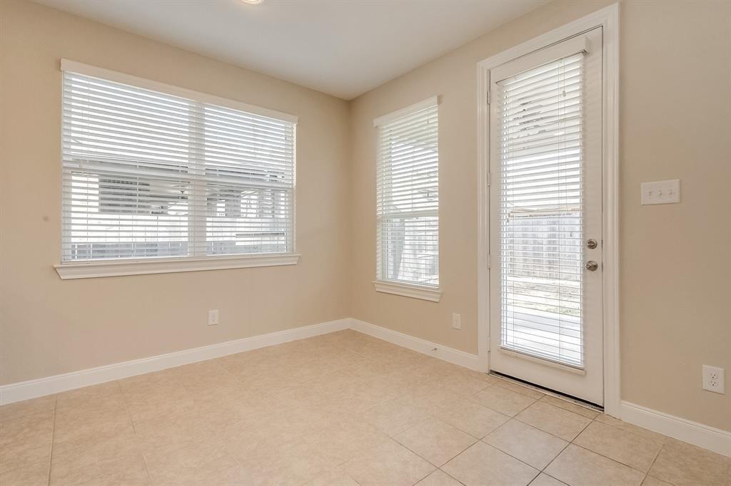 Empty room with tiled floor, large blinded windows, and a glass exterior door.