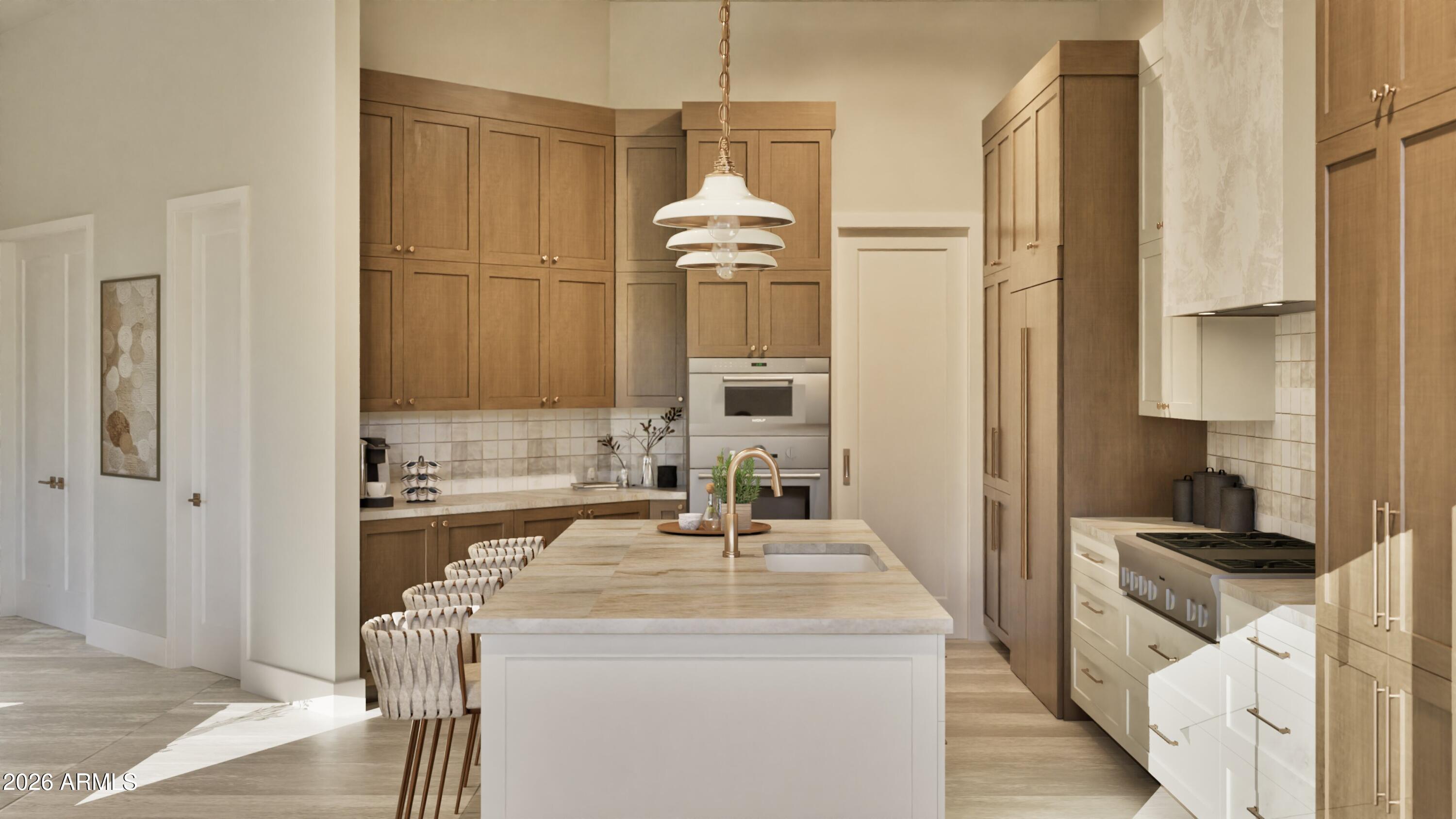 Kitchen with a large white island, warm wood cabinetry, double ovens, and a gas range.