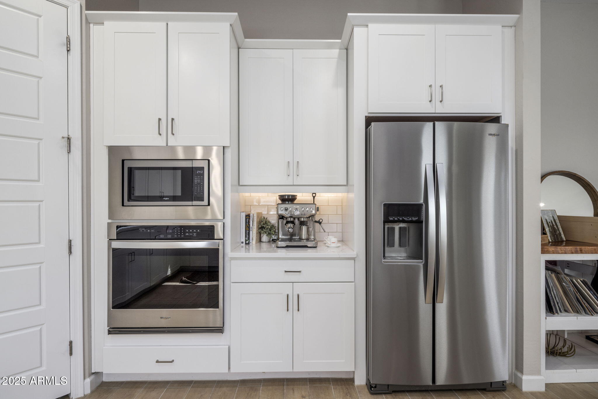 Kitchen with white cabinetry, stainless steel appliances, and an espresso machine on the counter.