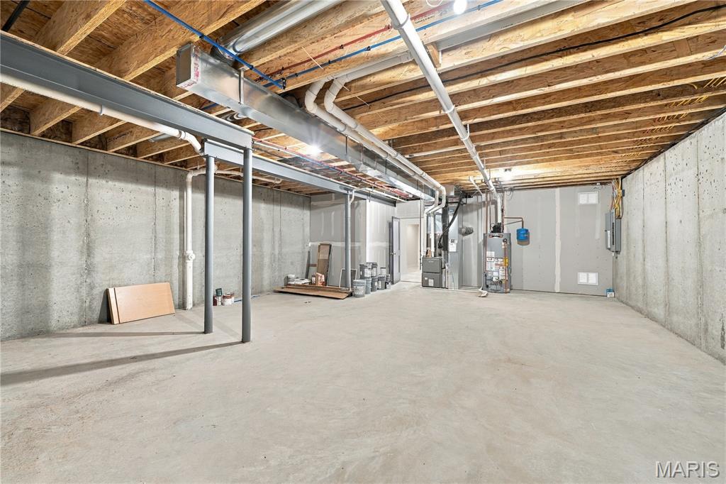 Unfinished basement with exposed joists, concrete walls, and mechanical equipment.