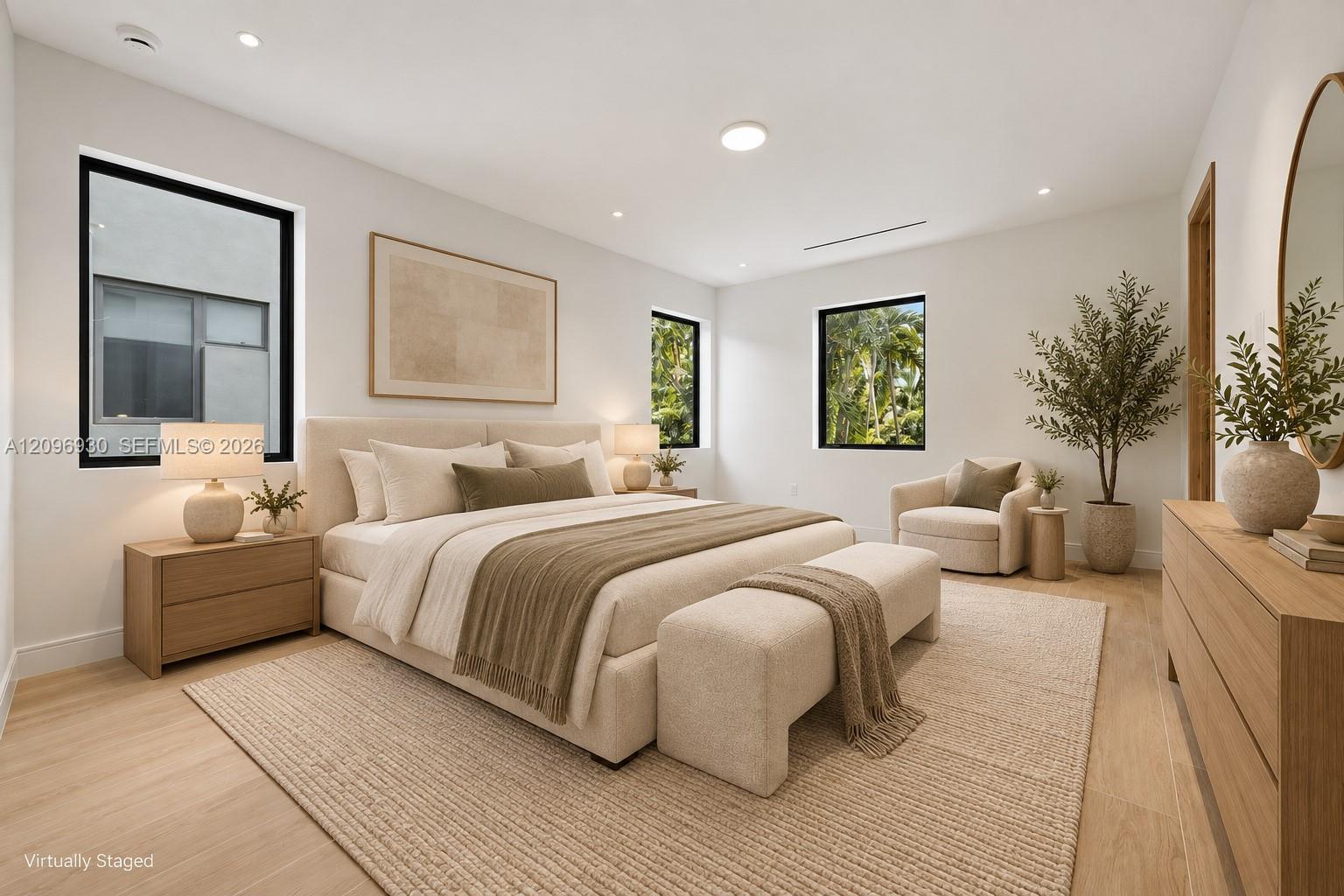 Virtually staged bedroom with a king bed, upholstered bench, and tropical greenery outside the windows.