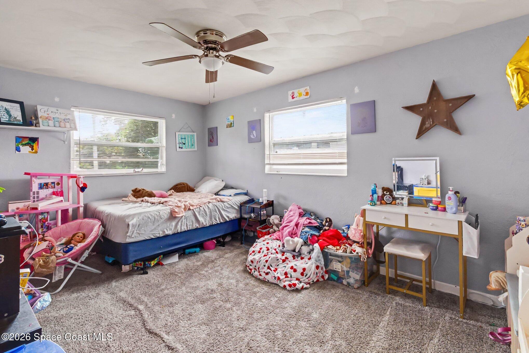 Child's bedroom with gray walls, a bed, toys, and a vanity.