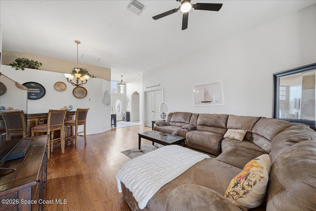 Living room with a large sectional sofa, wood flooring, and an adjoining dining area.