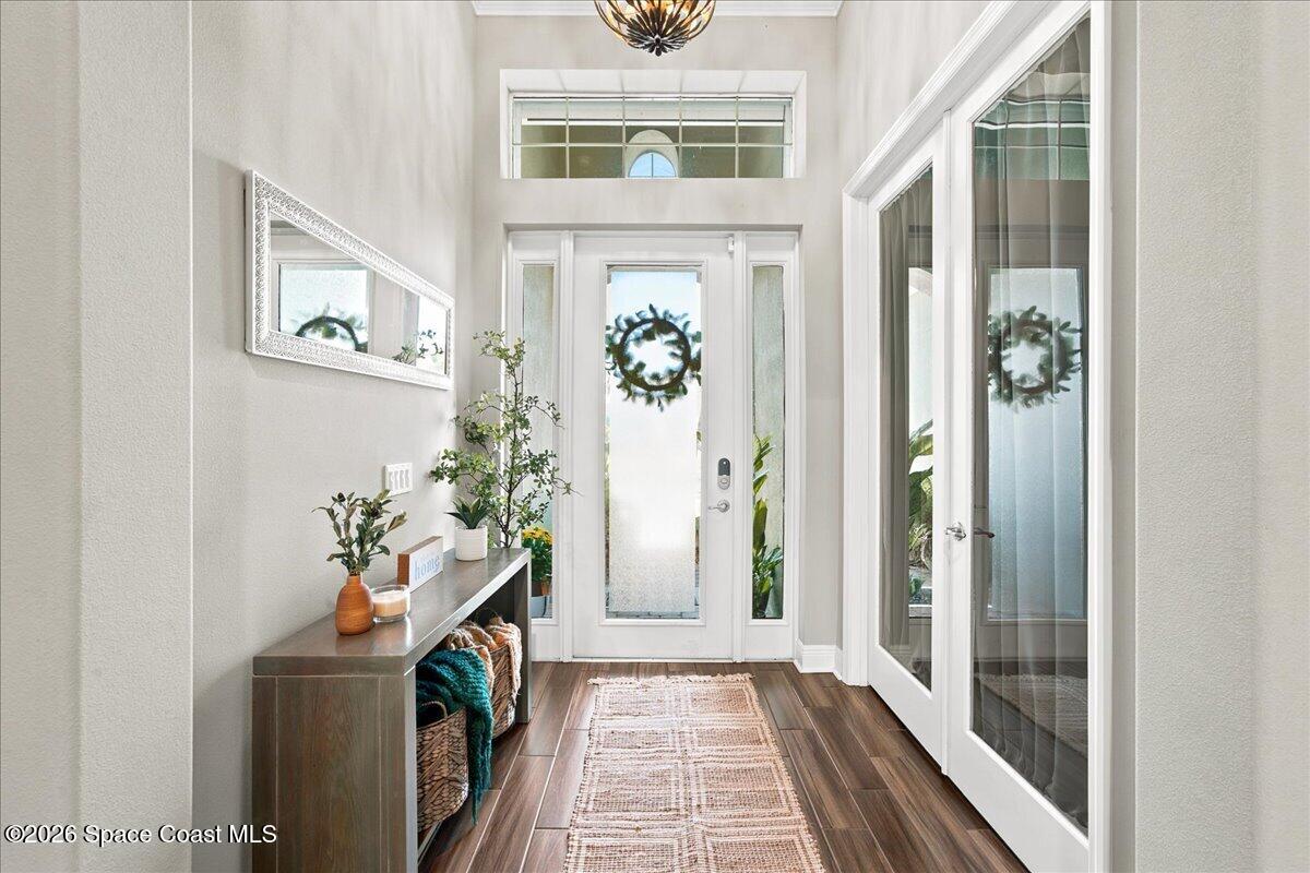 Bright entry foyer with a glass front door, high transom window, and console table.