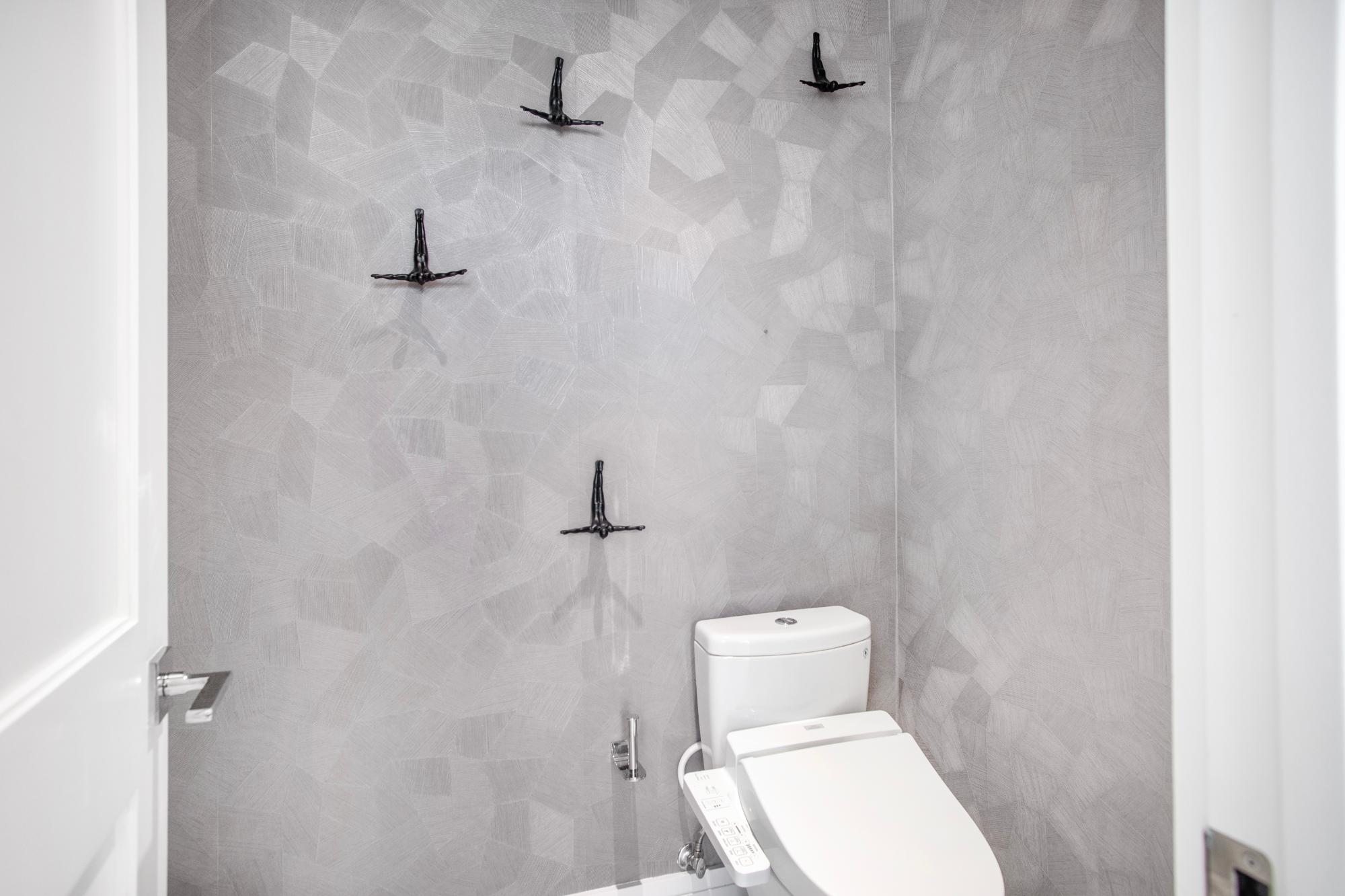 Modern bathroom with a bidet toilet and gray geometric tile walls.