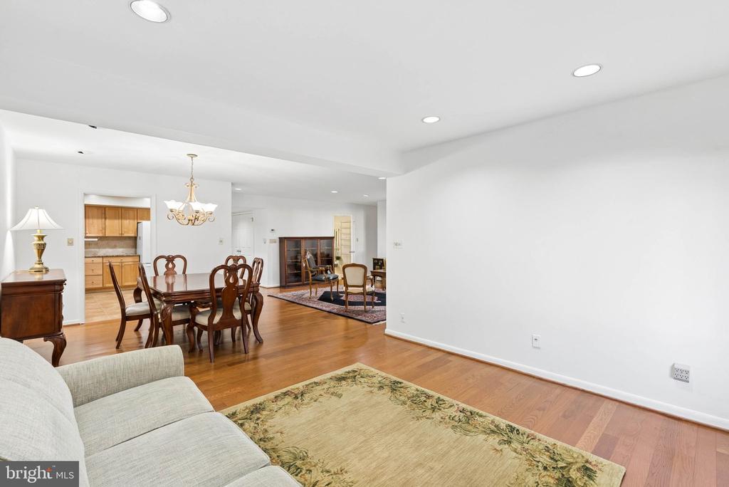 Open living and dining area with hardwood floors, a wood dining set, and an adjoining kitchen.