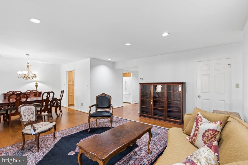 Living and dining room with hardwood floors, patterned rug, and traditional wood furniture.