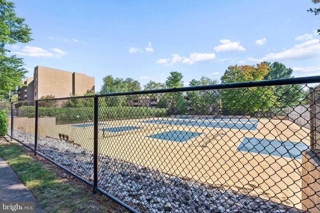 Outdoor swimming pool enclosed by a chain-link fence at a residential complex.