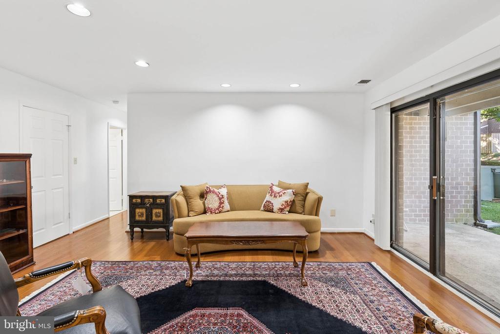 Living room with a tan sofa, patterned rug, and sliding glass doors to a patio.