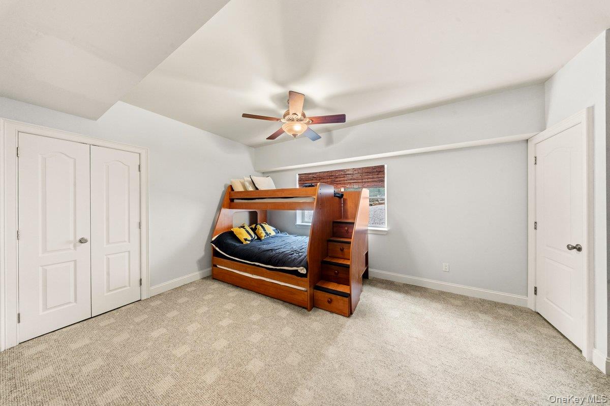 Bedroom with a wooden bunk bed featuring built-in stairs and drawers.