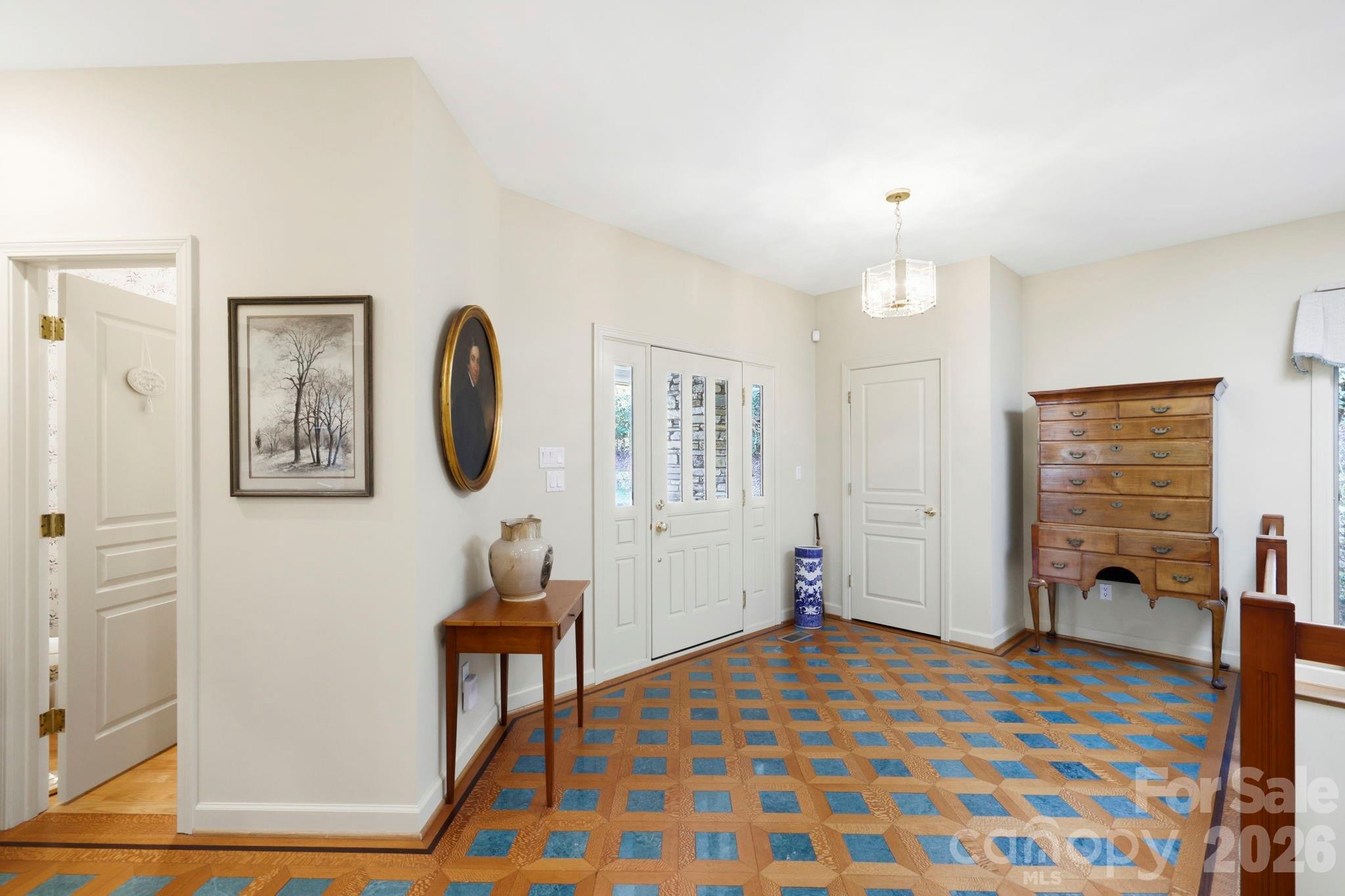 Foyer with glass-paneled double doors and a blue-and-tan geometric tile floor.