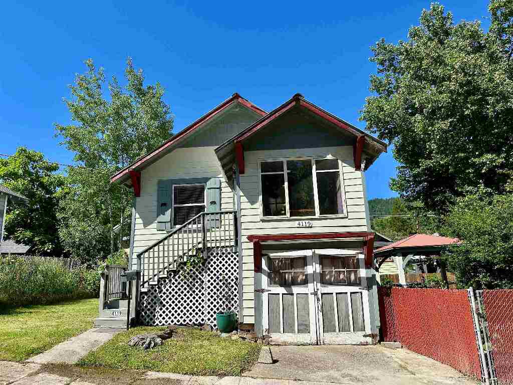 House at 4119 Edyth St with red trim, exterior stairs, and a wide garage door.