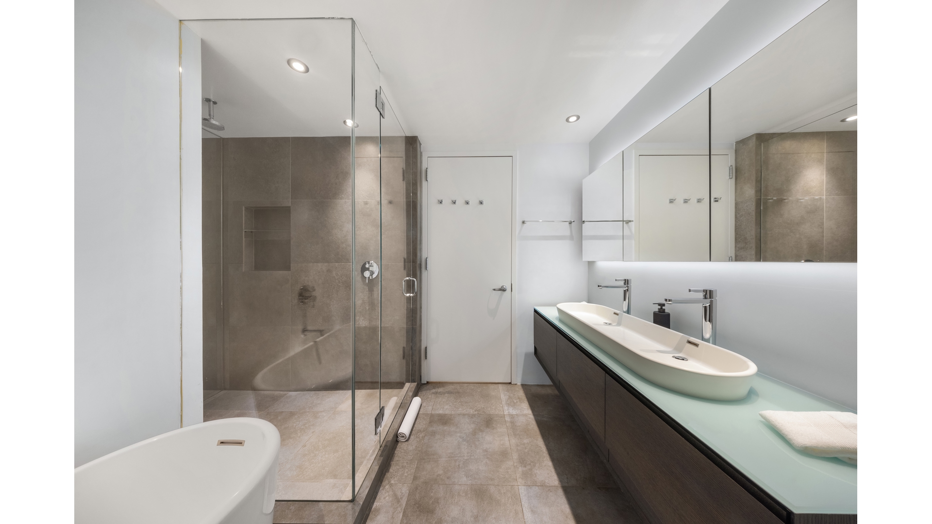 Modern bathroom with a glass shower, soaking tub, and double vanity.