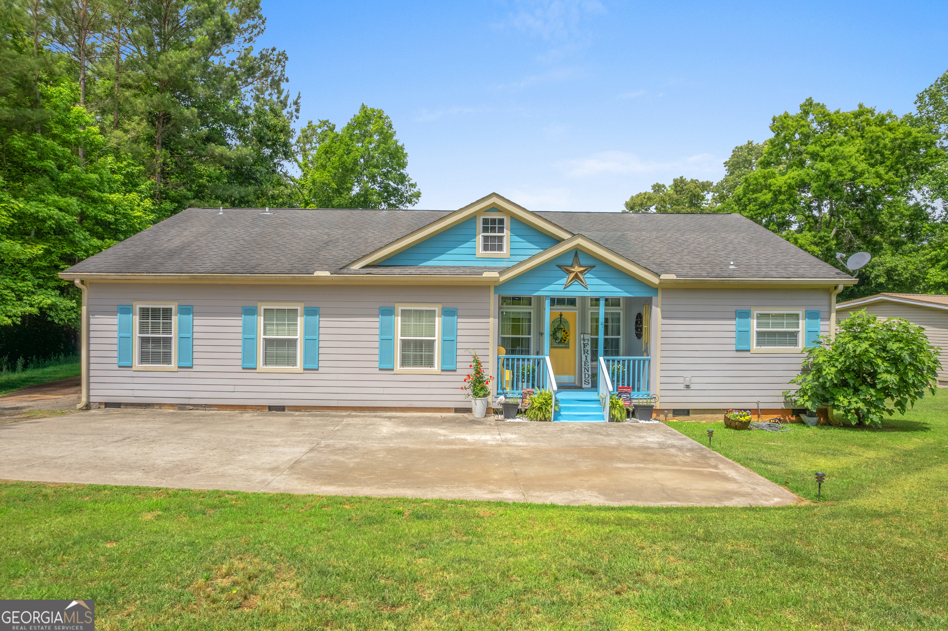 Gray single-story home with bright blue shutters, a blue porch, and a star above the entry.