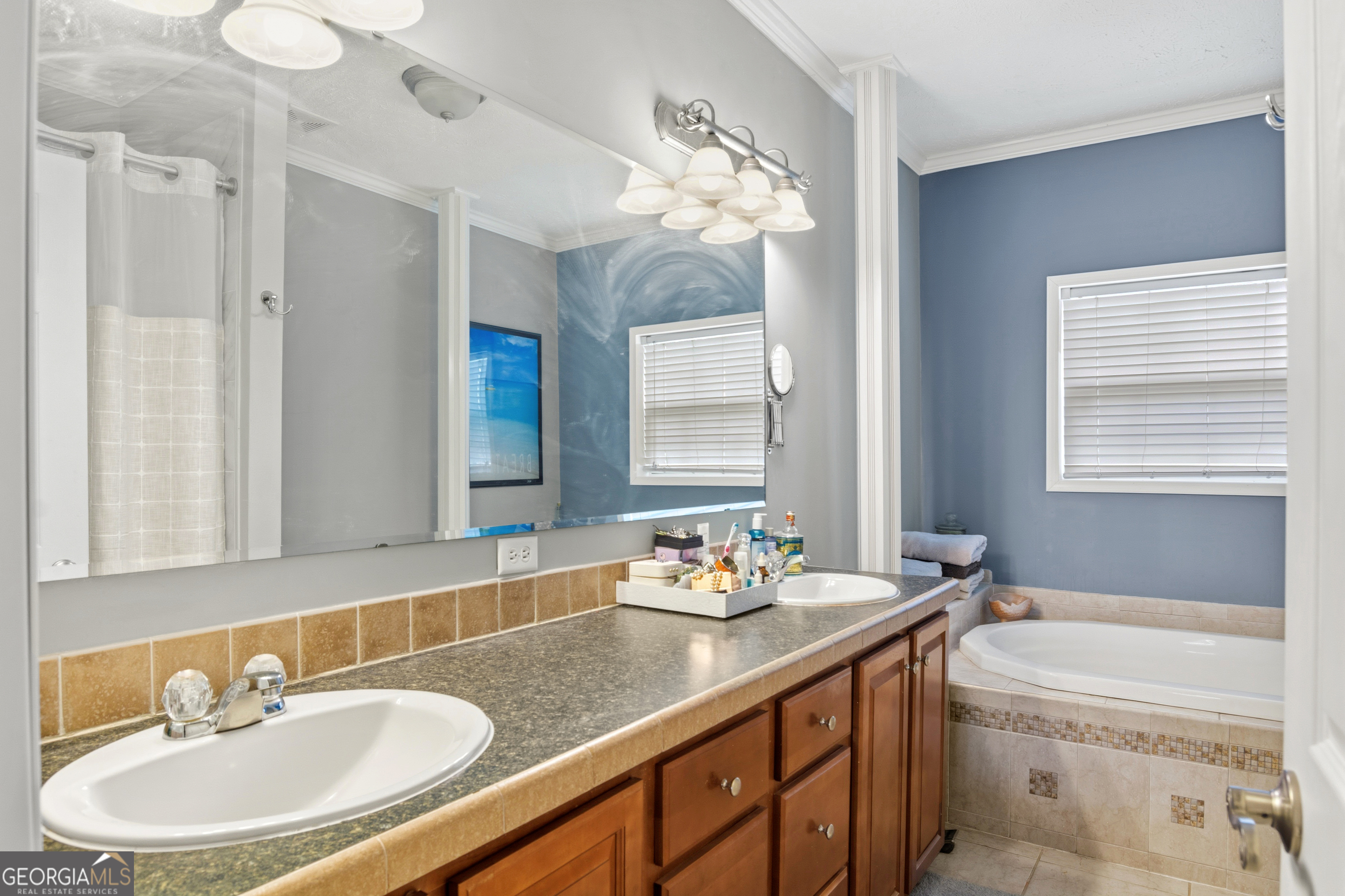 Bathroom with a long double-sink vanity and a built-in corner bathtub.
