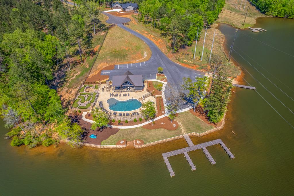 Lakeside pavilion and swimming pool beside docks extending into the water.