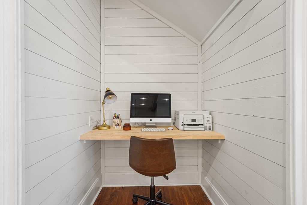 Compact home office with a built-in desk, computer, and brown chair.