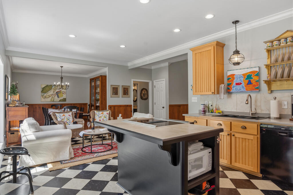 Kitchen with a dark cooktop island, warm wood cabinetry, and checkerboard tile flooring.