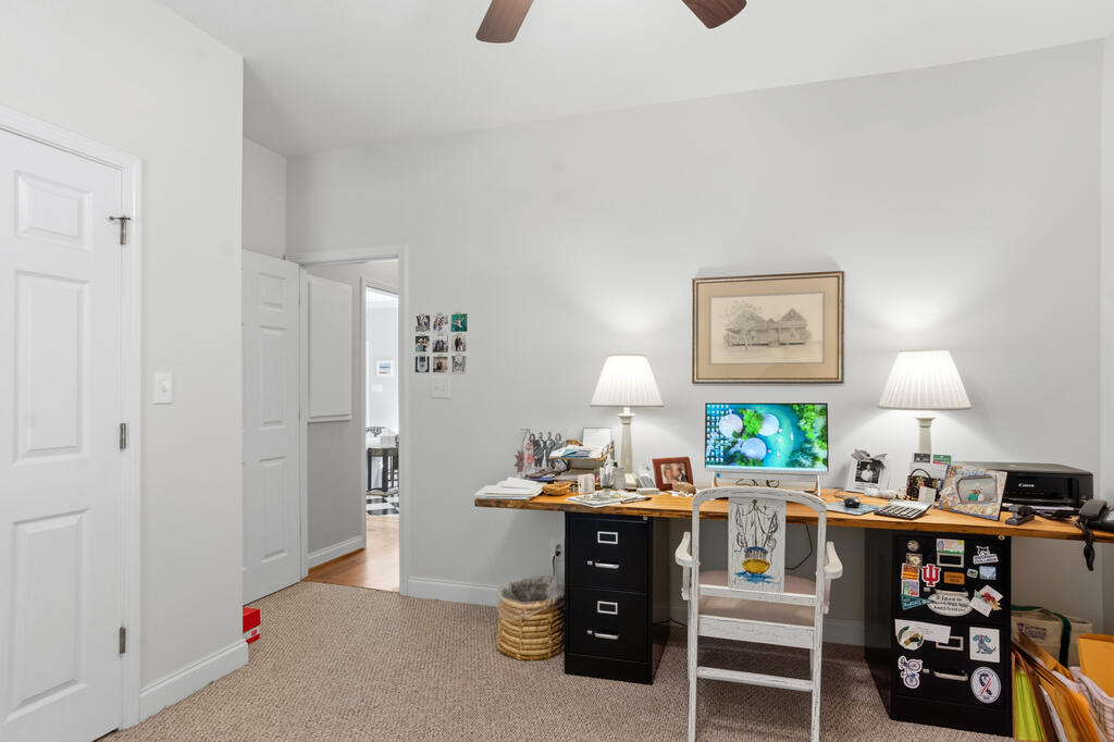 Home office with a long desk, computer, two lamps, and filing cabinets.