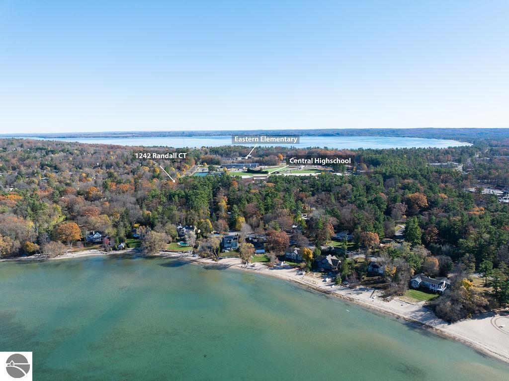 Aerial view of 1242 Randall Court on a wooded lakeshore, with nearby schools labeled.