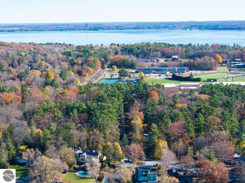 Aerial view of a wooded neighborhood, athletic fields, and a broad lake beyond.