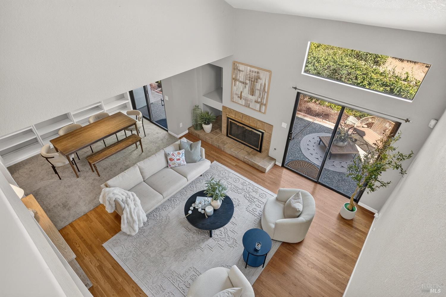 Open-plan living and dining room with a tiled fireplace and sliding doors to a patio.