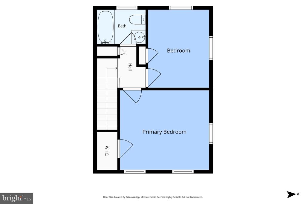 Upper-level floor plan showing two bedrooms, a bathroom, hall, stairs, and walk-in closet.