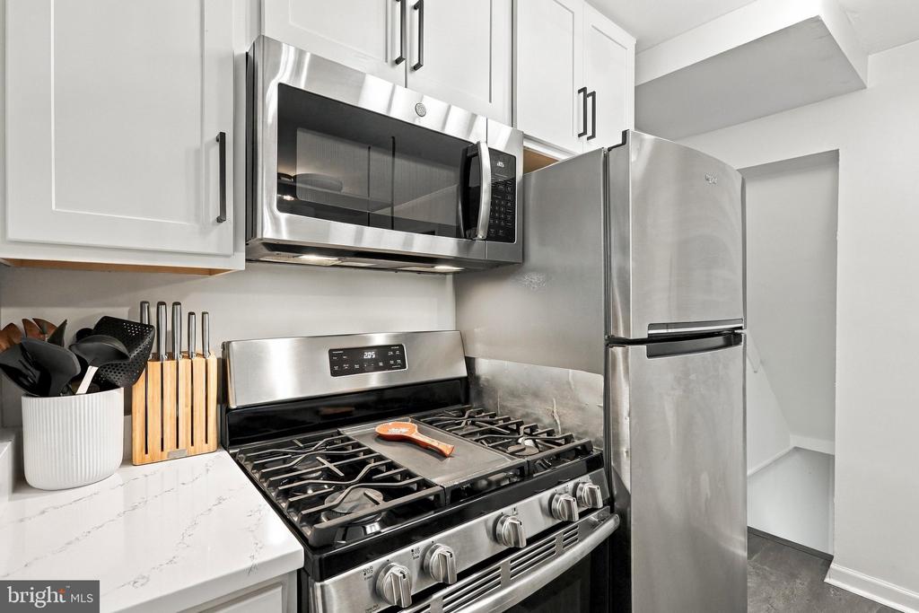 Kitchen with white cabinets, stainless steel appliances, and a gas range.