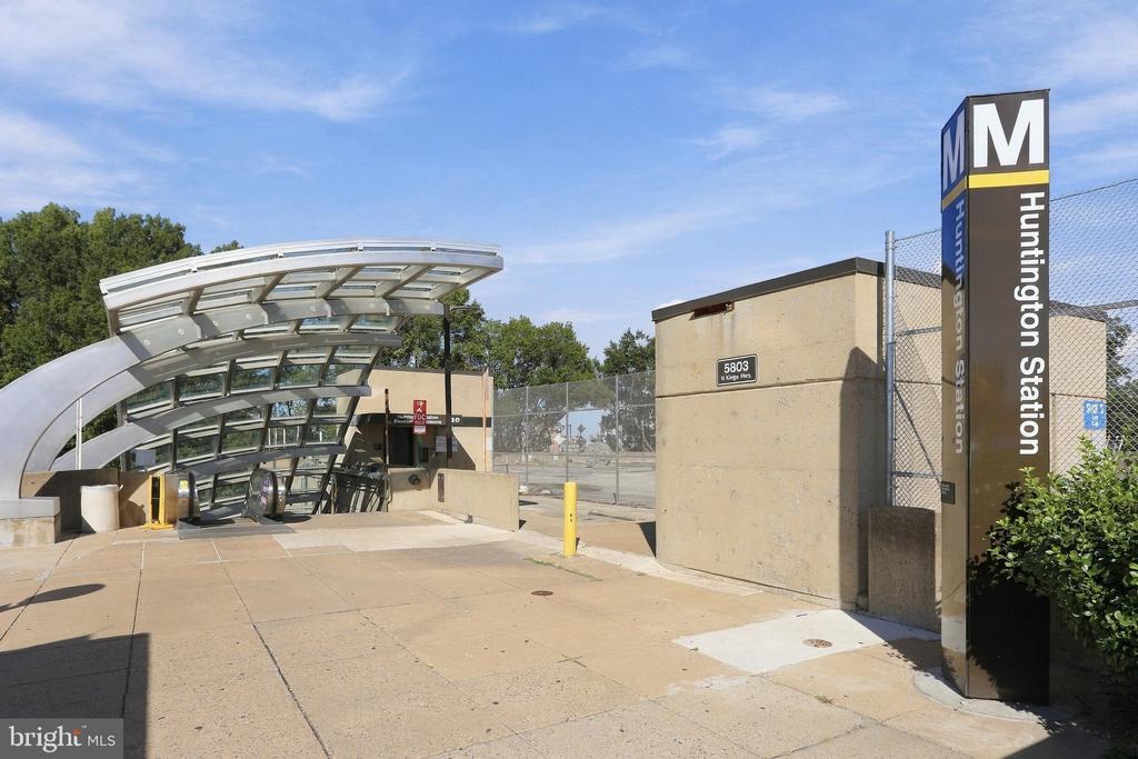 Huntington Station entrance with a curved glass canopy and tall station sign.